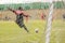 Soccer girl goalkeeper shoot in grass field.