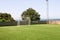 Soccer goal door with white net. Football goal at soccer field with green grass and sport stadium on campus, white line.