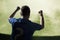 Soccer player with arms raised cheering, stadium with green sky