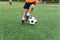 Soccer player kicking ball on field. Soccer players on training session. Close up footballer feet kicking ball on grass.