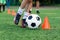 Soccer player kicking ball on field. Soccer players on training session. Close up footballer feet kicking ball on grass.