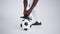 soccer player is tightening shoelace of football boots standing leg on ball, details in photostudio