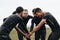 Soccer players joining hands in huddle talking about the game strategy. Footballers bending forward in a huddle holding hands