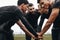 Soccer players joining hands in huddle talking about the game strategy. Low angle view of footballers bending forward in a huddle