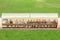 Soccer players and staff sit on bench beside the soccer field. (Home team)