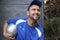 Soccer playing in blue shirt and cap holding silver ball