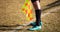 Soccer referee assistant stands at sideline with flag at hands. Blur green field background, close up.