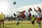 Soccer team, man and ball kick in air during football match, competition or training. Sports, fitness and soccer players