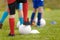 Soccer training drill for kids. Legs of football players attending soccer class. Children playing sports outdoor. School kids in