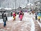 Sochi, Russia - 25 February 2020. Snowboarders and skiers with equipment go along the sidewalk of the ski resort to the