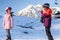 Sochi, Russia - January 7, 2018: Female ski instructor teaches skiing to small girl on snowy mountain peak background. Both ride o