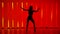 Social dancing. Energetic young woman practicing salsa sharp movements. Silhouette of a dancer in the studio against a