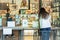 Social distance conceptual woman customer looking at menu with waiter standing in cafe.