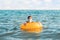 Social distance and virus protection. A woman in a medical mask swims in the sea with an inflatable circle. In the background, the