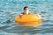 Social distance and virus protection. A woman in a medical mask swims in the sea with an inflatable circle. Copy space