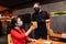 Social distancing during the covid-19 coronavirus pandemic. A restaurant visitor wearing a face mask making an order through the