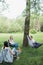 Social distancing. Small group of people enjoying conversation at picnic with social distance in summer park. Leisure activity