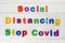 Social Distancing  stop covid Sign & Symbol, plastic letter on white wood background