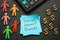 Social impact bonds sign, calculator and figurines.