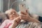 Social isolation, loneliness in older people, health risks. Age-group risk for coronavirus. Lonely elderly woman with smartphone