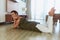 Social Isolation. Woman Wrapped In Yoga Mat After Exercising. Smiling Brunette Relaxing On Floor In Living Room After Daily Sport.