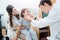 Social little girl in being examined by pediatrician, sitting on mom`s lap