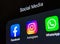 Social media products from Facebook company: Facebook, Instagram, WhatsApp apps on the smartphone screen.