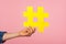 Social media trends. Closeup of female hand holding yellow hashtag sign, sharing tagged message