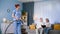 social worker, young woman in a medical suit with a vacuum cleaner in hands cleans room of elderly people