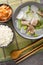 Soegogi muguk Beef and radish soup is a very popular soup in Korea served with rice and kimchi closeup on the mat. Vertical top