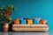 Sofa with multicolored pillows and wicker pot with houseplant against teal wall with copy space