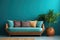 Sofa with multicolored pillows and wicker pot with houseplant against teal wall with copy space
