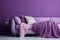 Sofa and pouf covered with blanket against purple wall with copy space. Minimalist interior design of modern living room