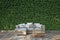 The sofa sits on a wooden deck in the garden behind a tall bush wall. 3D illustration