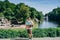 Sofia Park, Ukraine. Man with a backpack on the background of the lake with a fountain and a white gazebo. A man walks in a