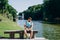 Sofia Park, Uman. Handsome young man sitting on a bench on the background of the lake. Male tourist with a backpack sitting on a