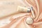 Soft 3d realistic cosmetic ad. Silk glowing fabric light rose beige silver package