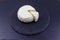 Soft Adyghe cheese on black slate background