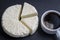 Soft Adyghe cheese with white cup coffee on black slate background, close up, top view. Home cheese making