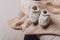 Soft baby shoes, booties on beige cocoon, baby nest for newborn over cribs in nursery. Childhood concept. Eco