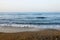 Soft beautiful ocean wave on sandy beach in the sunset.