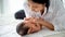 Soft blur and close-up view of mother look to her newborn baby on white bed with soft day light as emotion of love, careful and