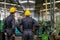 Soft blur image of the back of two technician men stand and look to various type of machine in factory