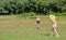 Soft blur of two teen girls play with kite in grass field of park or garden with day light