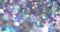 Soft and blurry bokeh glitter background with shiny floating particles with a shimmering rainbow reflection