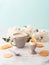 Soft-boiled egg with liquide orange yolk in ceramic egg cup, cup of coffee and thin crispy corn chips on background of