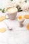 Soft-boiled egg with liquide orange yolk in ceramic egg cup, cup of coffee and thin crispy corn chips on background of