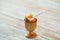 Soft-boiled egg in wooden egg cup showing runny yellow yolk with matching white ceramic spoon
