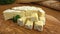 Soft brie cheese cubes on rustic board