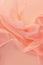 Soft coral chiffon fabric floating on a warm pastel background, ideal for fashion and textile design with a sense of